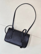 Chanel handbag front view with flap and strap loops, dark blue textured leather.