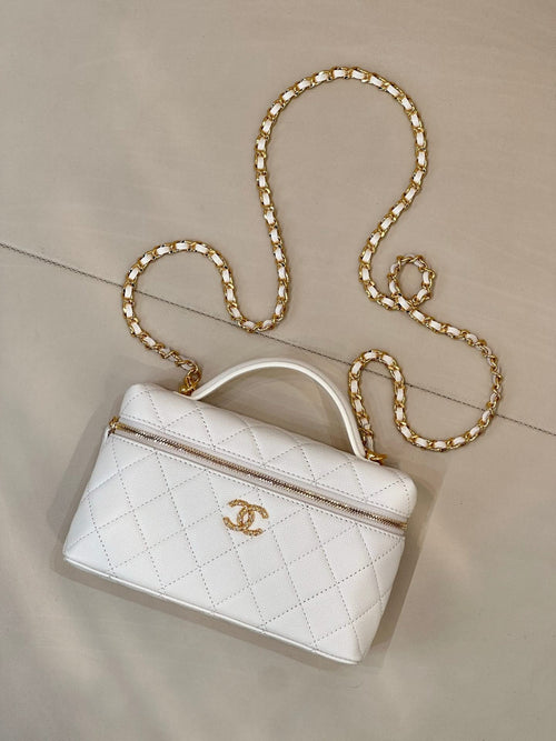 White quilted leather handbag with top handle, zip pocket, and gold chain strap.