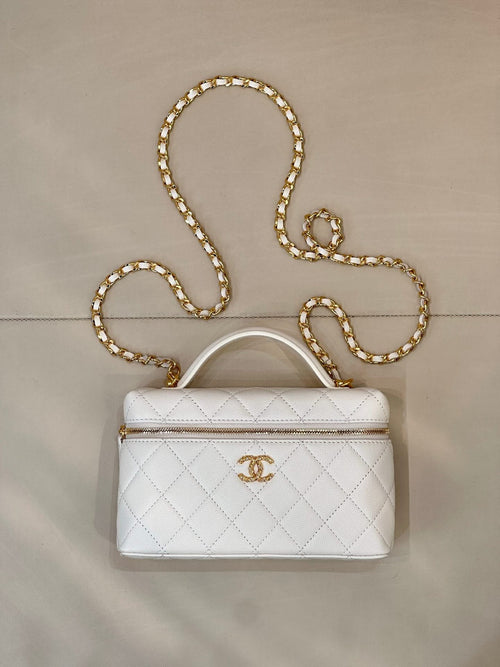 White quilted leather bag with top handle, zip closure, and gold chain strap.