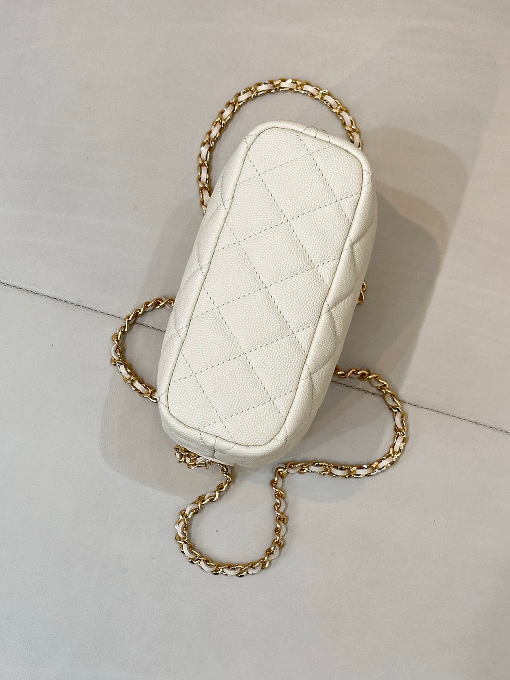 Chanel quilted mini bag, white, with gold chain strap and narrow oval shape