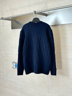 Dark navy cable-knit long-sleeve sweater back view on hanger.