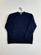 Dark navy cable-knit crewneck sweater with long sleeves, laid flat.
