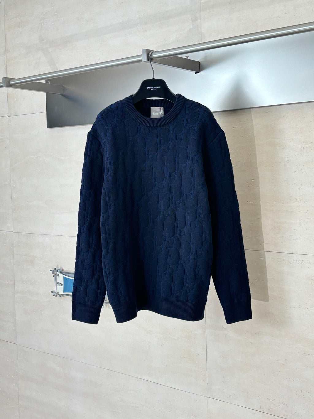 Dark navy cable-knit long-sleeve sweater on hanger, crew neck.
