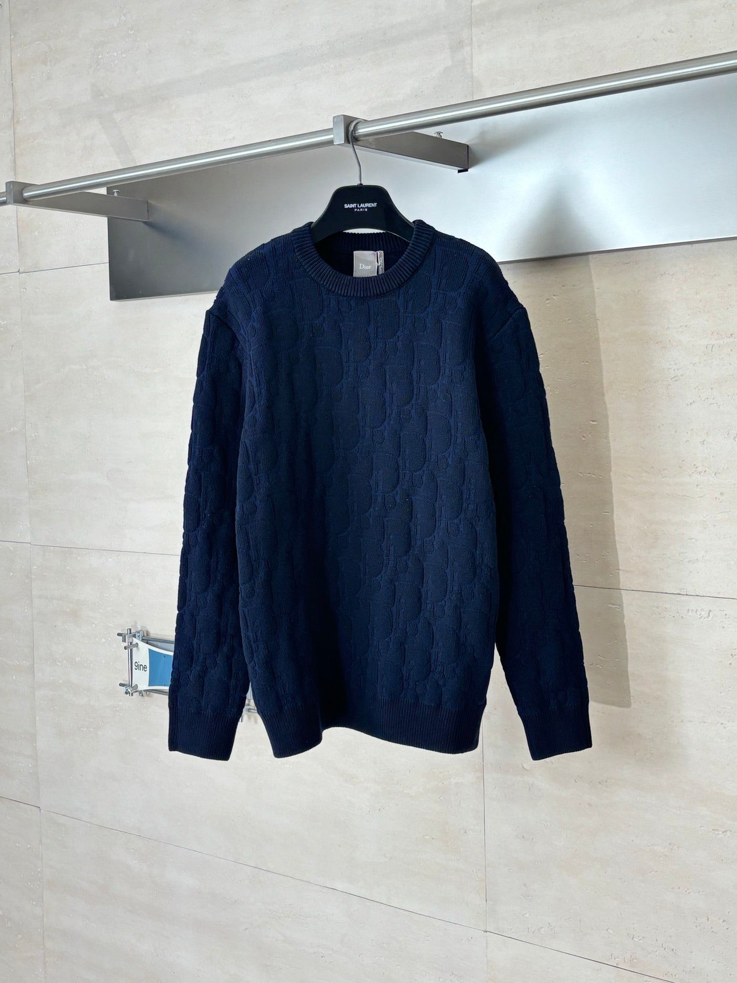 Dark navy cable-knit long-sleeve sweater on hanger, crew neck.