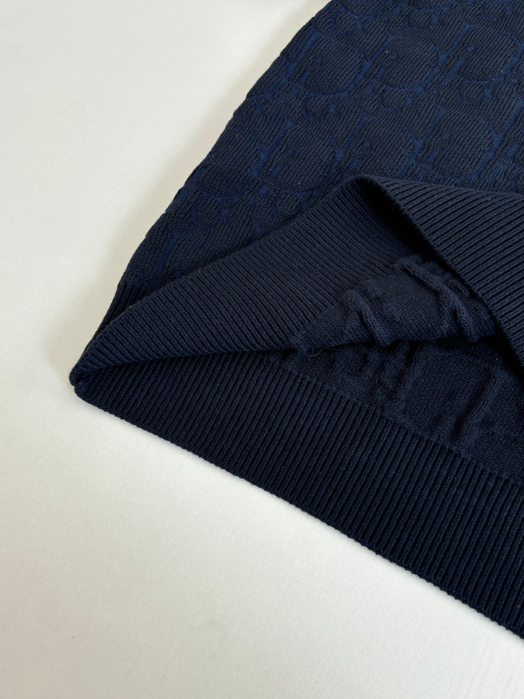 Dark navy ribbed-knit cuff and sleeve hem detail, folded edge.
