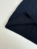 Dark navy ribbed-knit cuff and sleeve hem detail, folded edge.