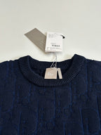 Dark navy cable-knit crewneck sweater with Dior tag at collar.