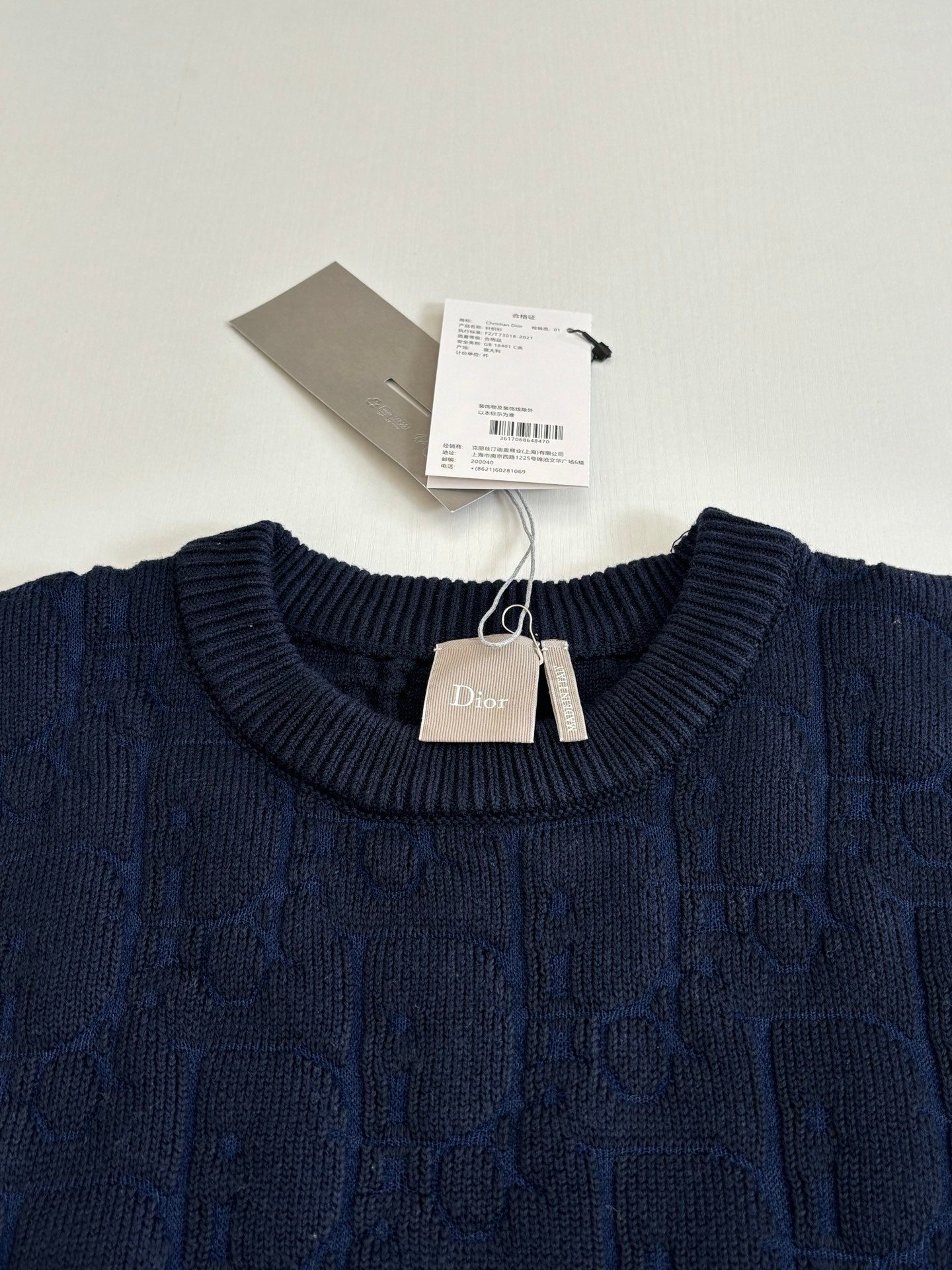 Dark navy cable-knit crewneck sweater with Dior tag at collar.