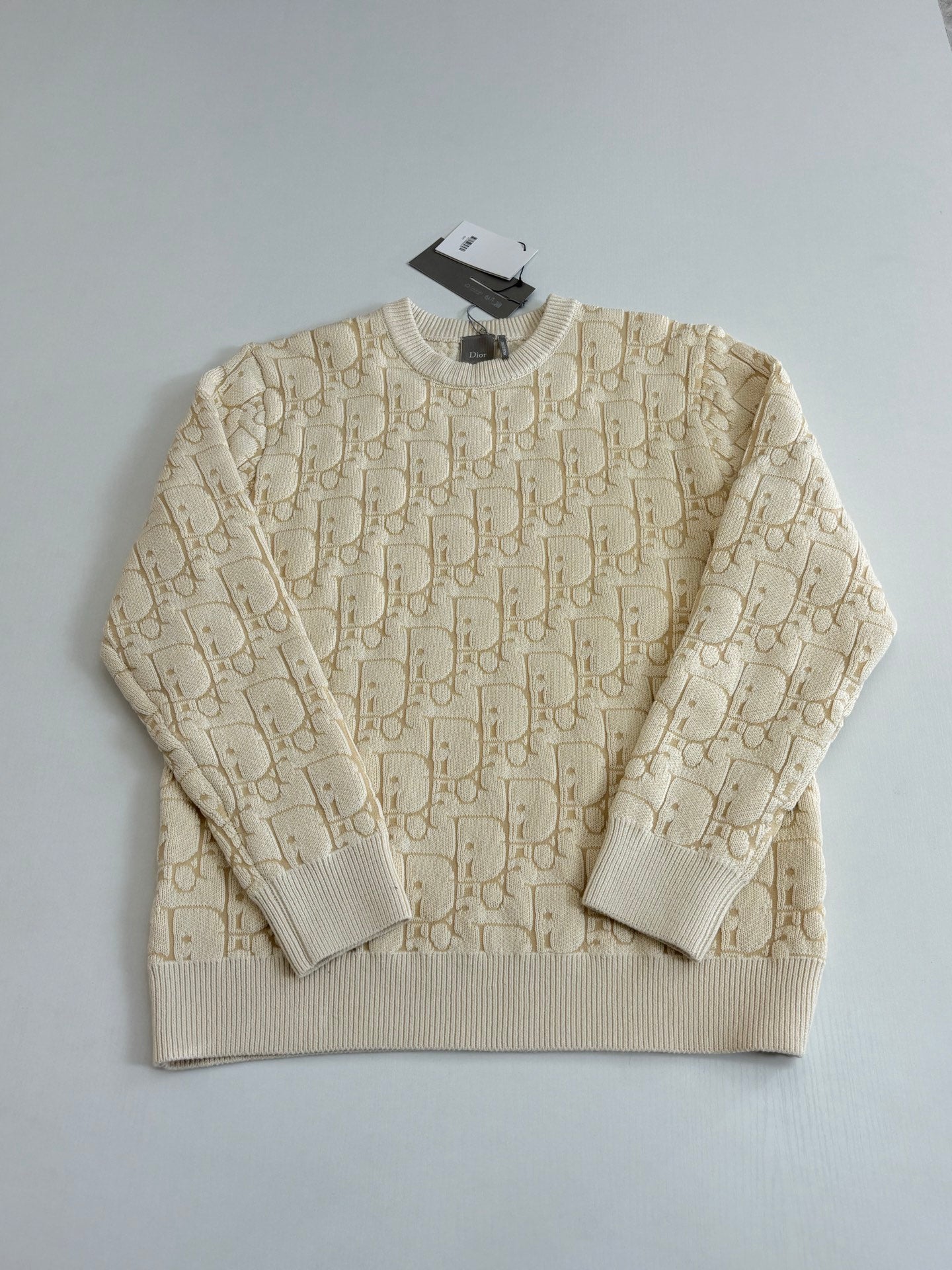 Cream jacquard knit sweater with crew neck and long sleeves, flat-lay view