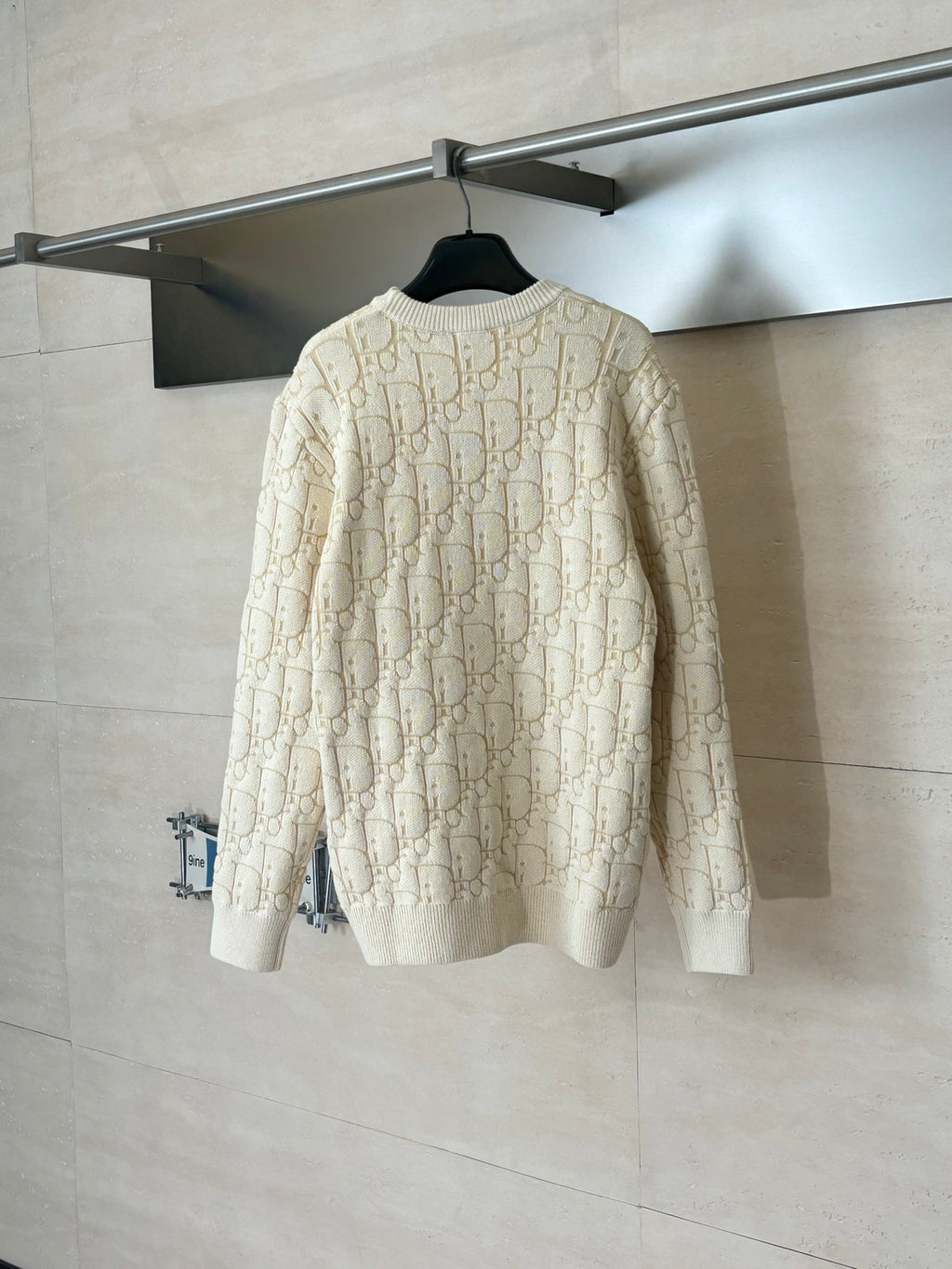 Back view of cream knit sweater with long sleeves and allover Dior-style logo pattern