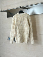Back view of cream knit sweater with long sleeves and allover Dior-style logo pattern