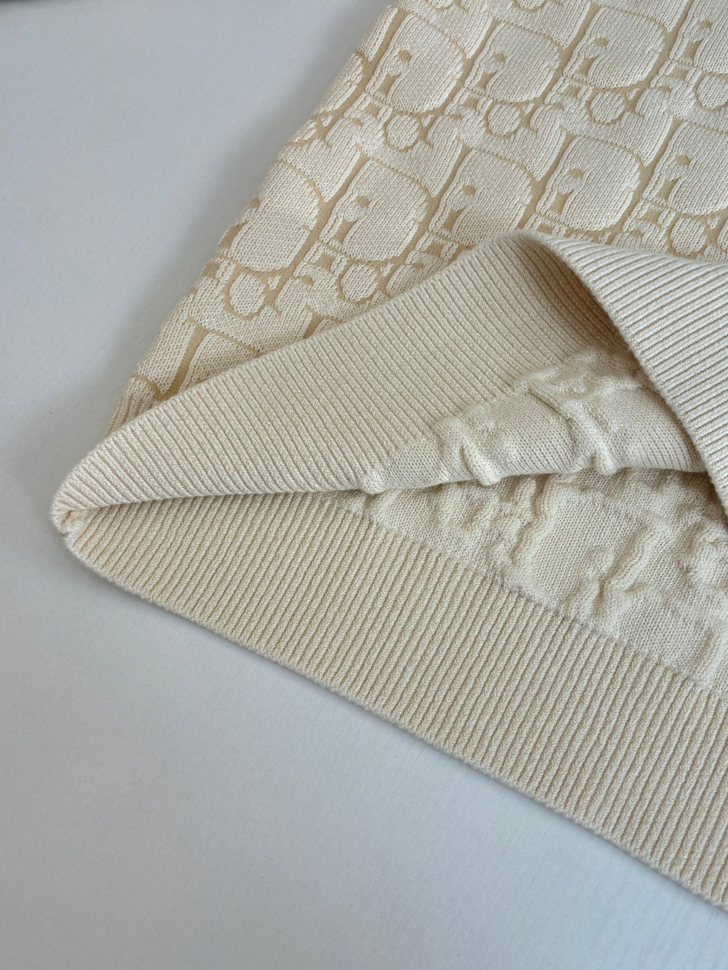 Cream ribbed knit legwarmer with cuff edge and Dior-style logo pattern