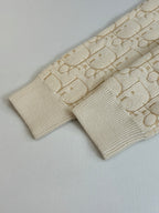 Cream jacquard knit sleeve with ribbed cuff, flat-lay close-up