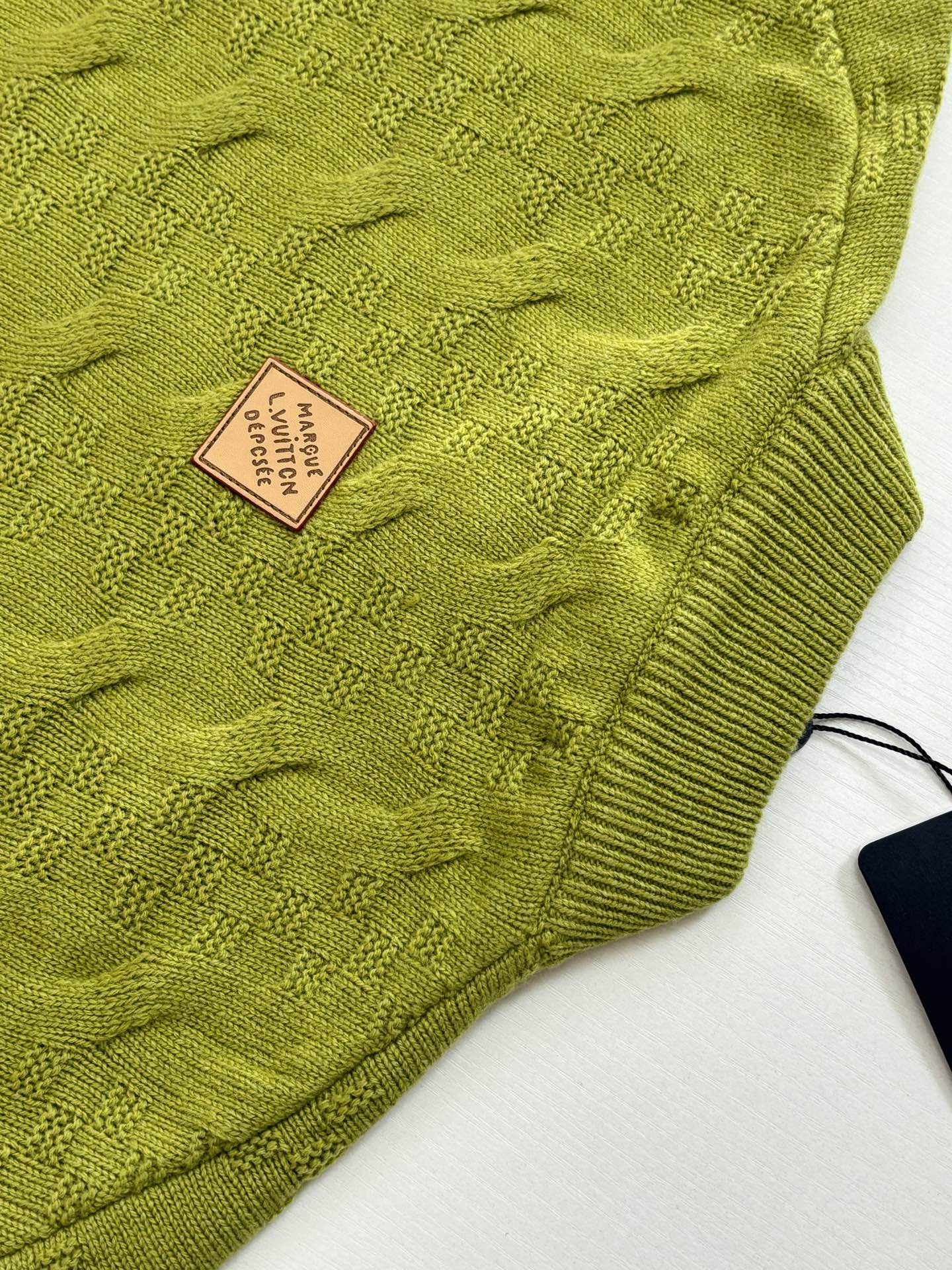 Lime green cable knit fabric with square logo patch label