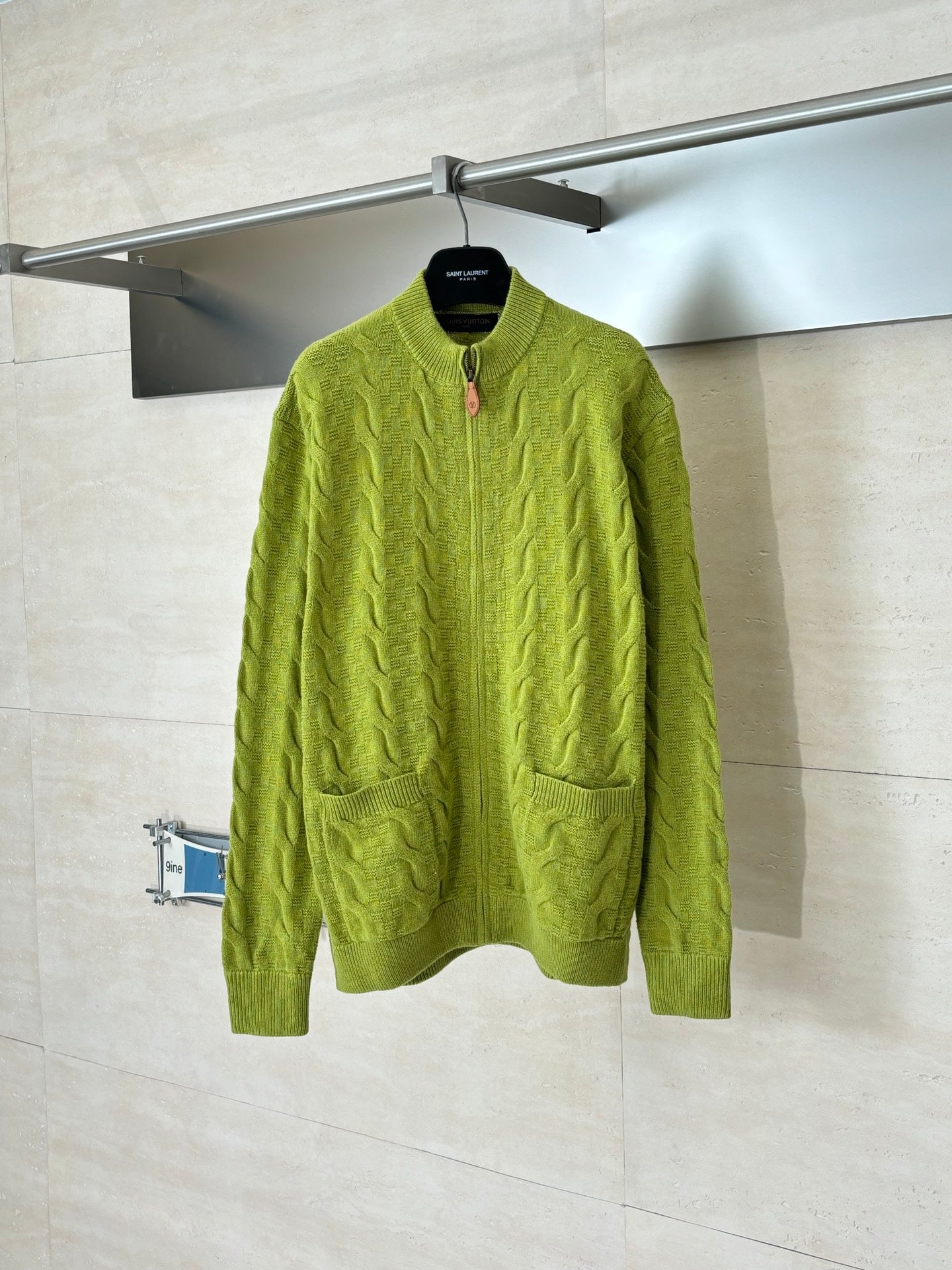 Green knit zip-up sweater with textured cable pattern and ribbed cuffs