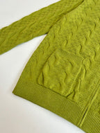 Green knit sweater sleeve with textured cable pattern and ribbed cuff