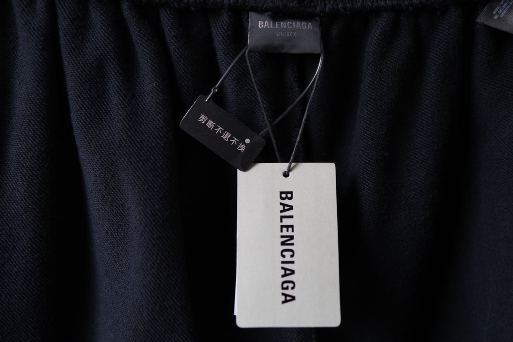 Black Balenciaga pants with brand hang tag at the waistband