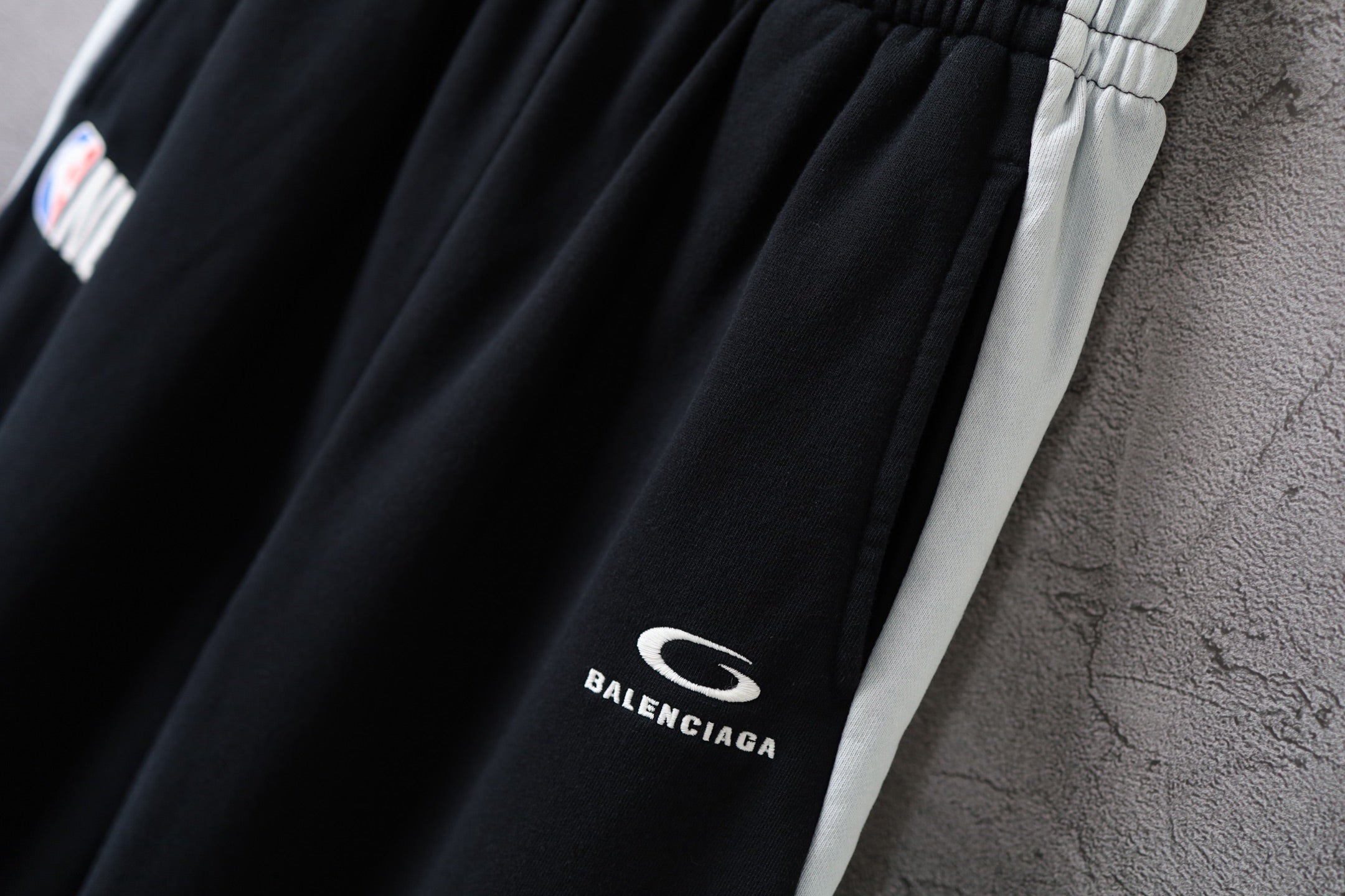 Black Balenciaga pants leg with small “BALENCIAGA” logo print