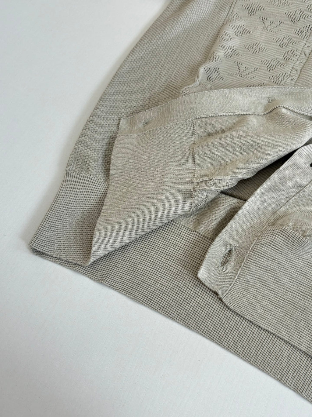 Beige cardigan sleeve and cuff with ribbed texture and angled folded view