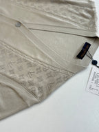 Light cream knit cardigan close-up of button placket and embossed pattern