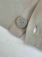 Beige cardigan sleeve cuff with round button and ribbed knit texture