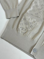 Beige cardigan with textured pattern at chest and ribbed hem, button placket visible