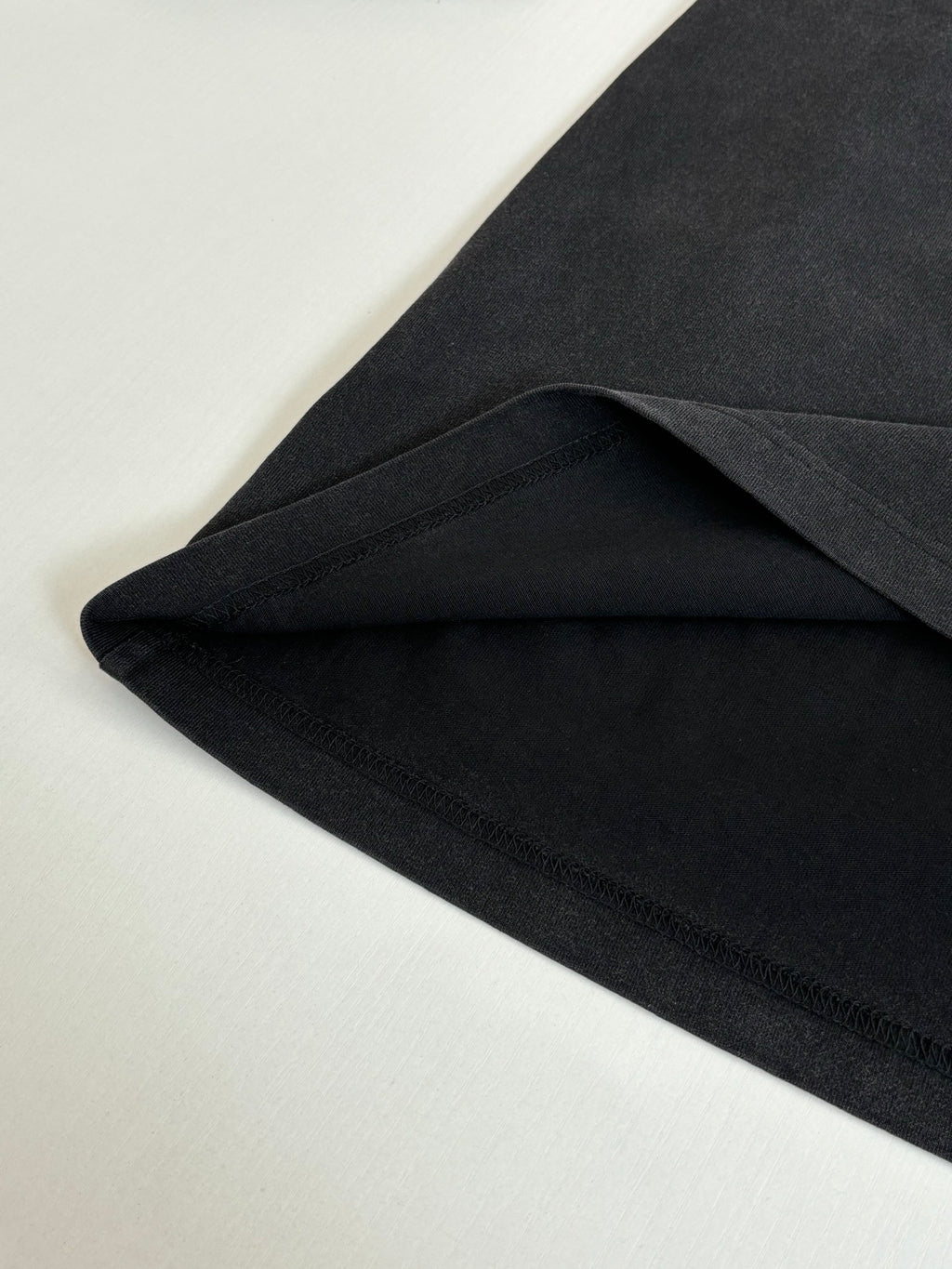 Folded dark long-sleeve T-shirt fabric with smooth neckline seam