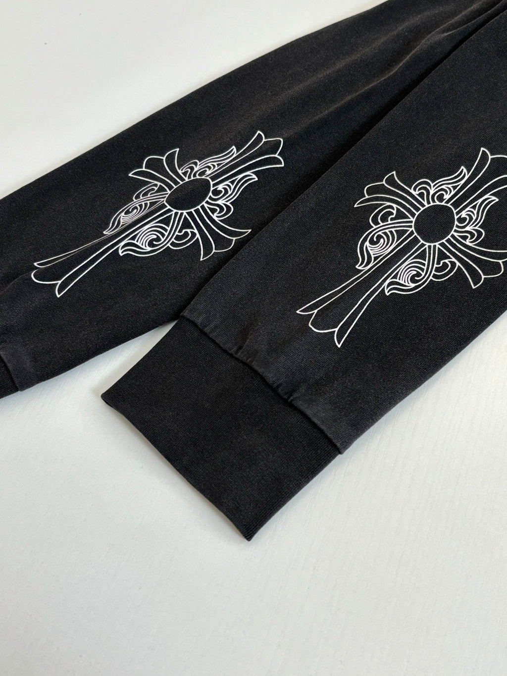 Black long-sleeve sweatshirt sleeves with white floral cross designs