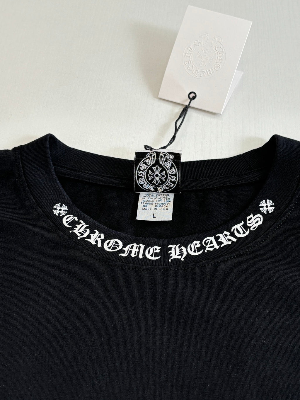 Black crew-neck T-shirt with embroidered-style logo across the neckline