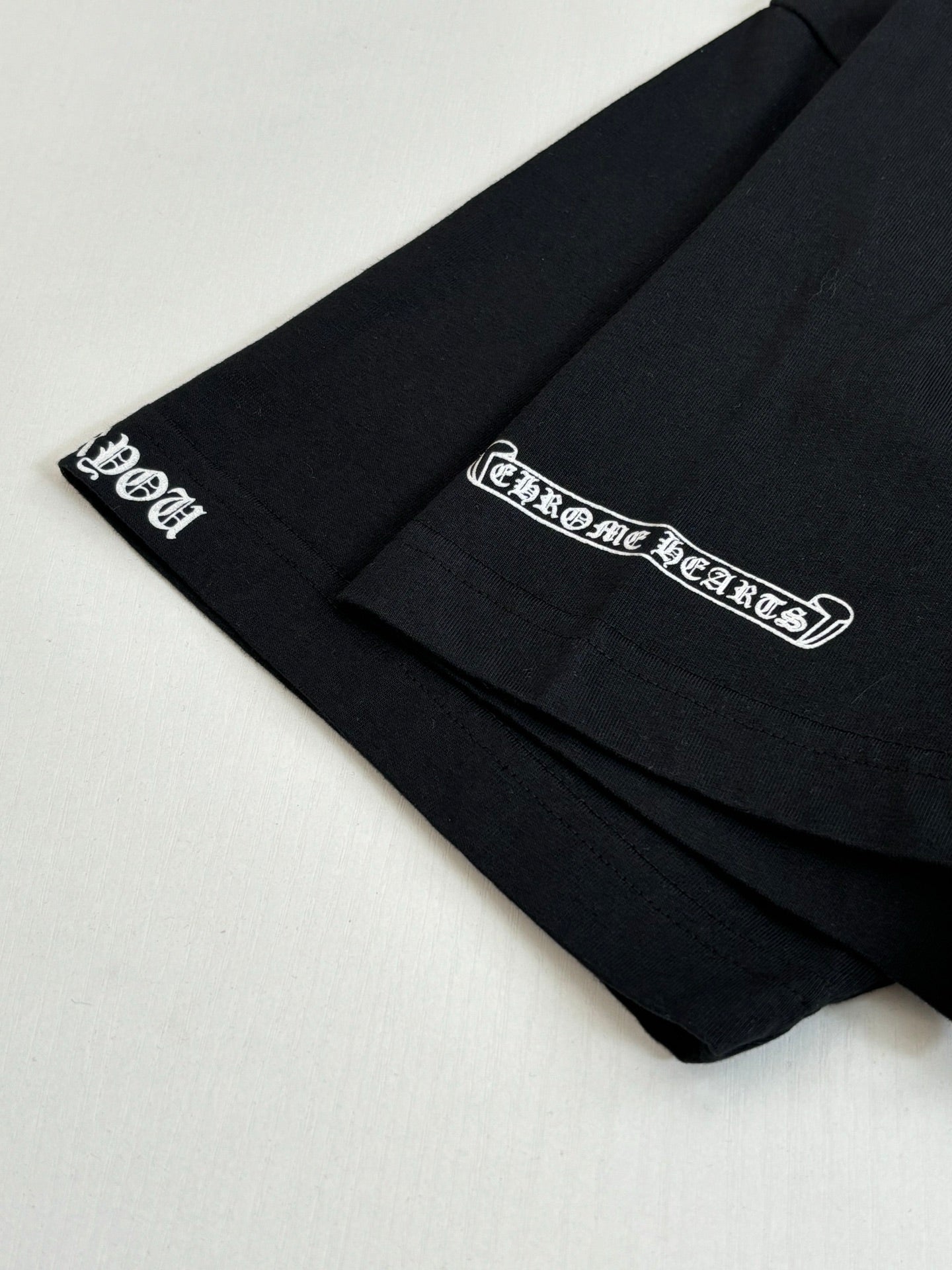 Black T-shirt sleeve cuff with small logo print