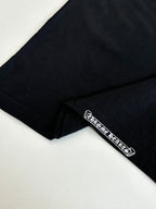 Black T-shirt close-up of sleeve hem with small logo patch