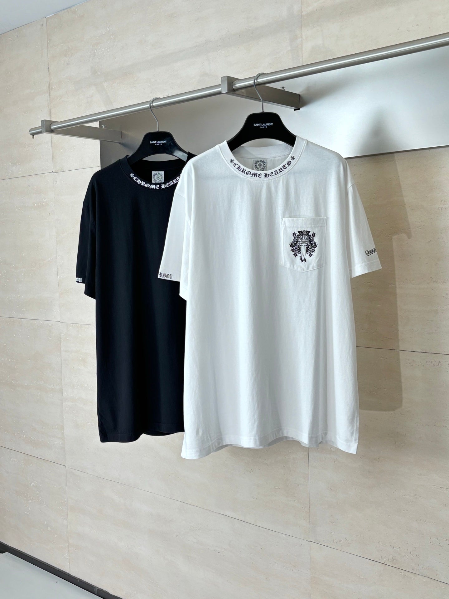 Two short-sleeve T-shirts: white and black, both with chest crest