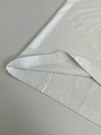 White T-shirt hem seam detail on plain fabric