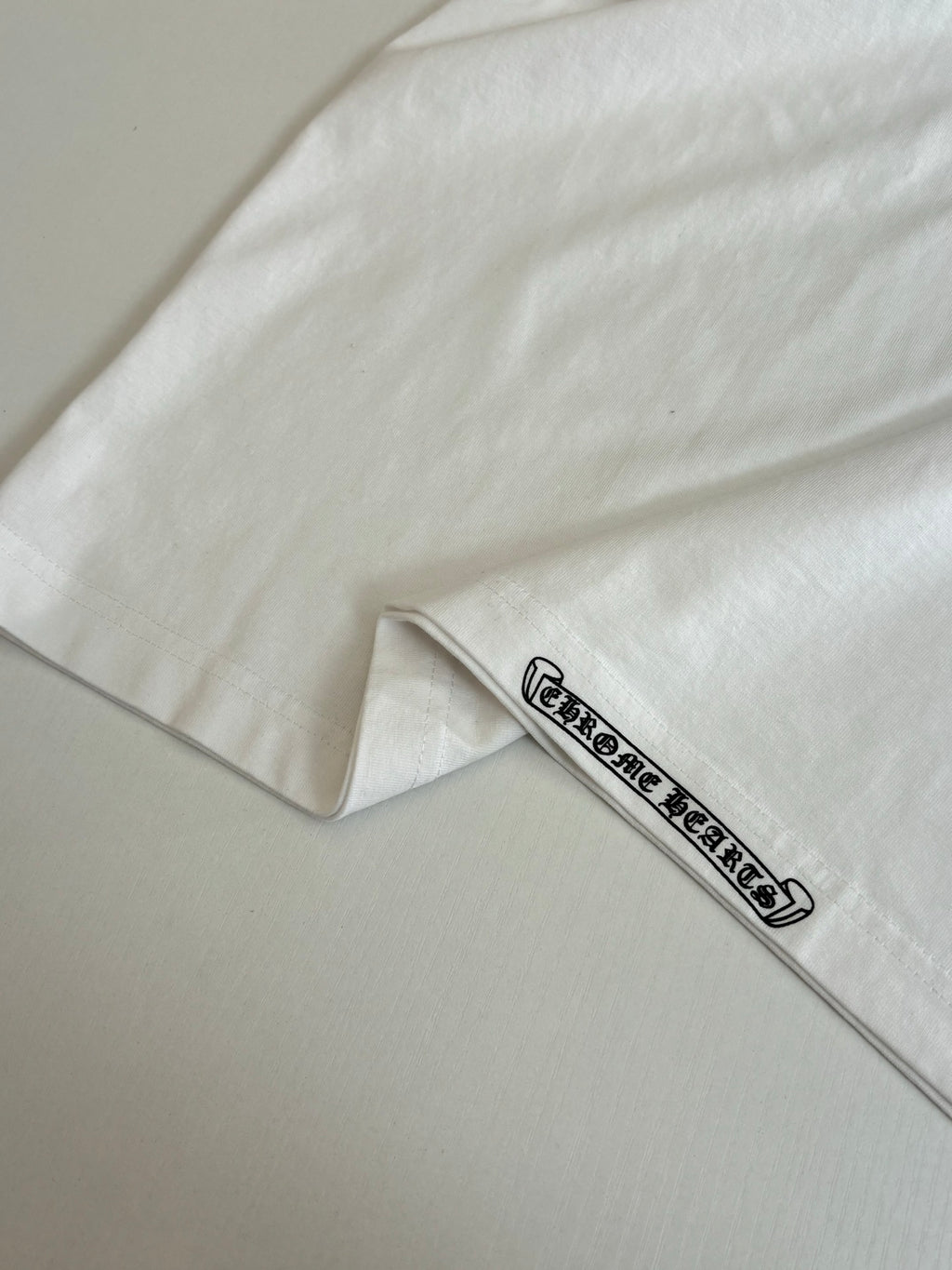 White T-shirt sleeve cuff detail with small logo band