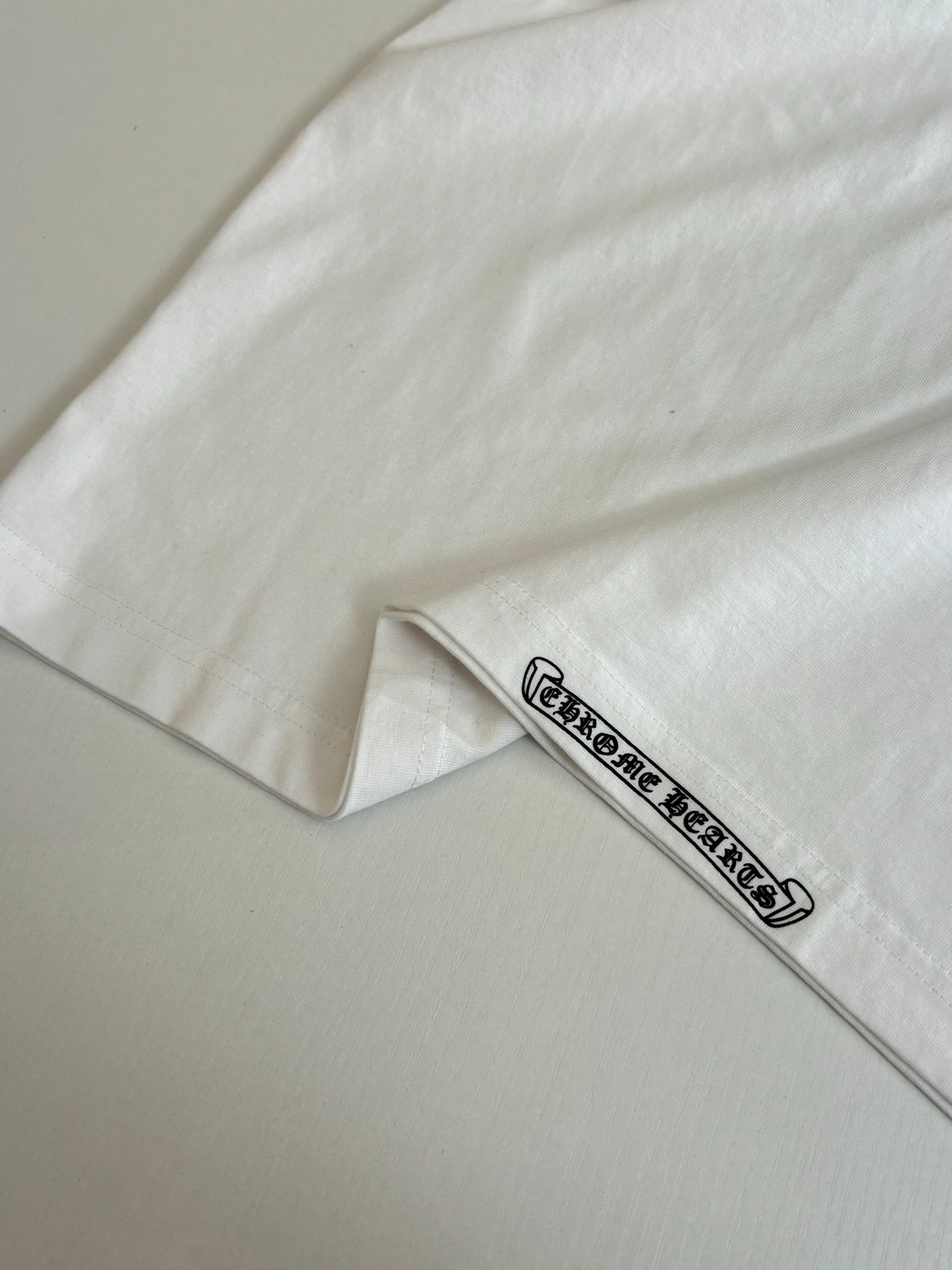 White T-shirt sleeve cuff detail with small logo band