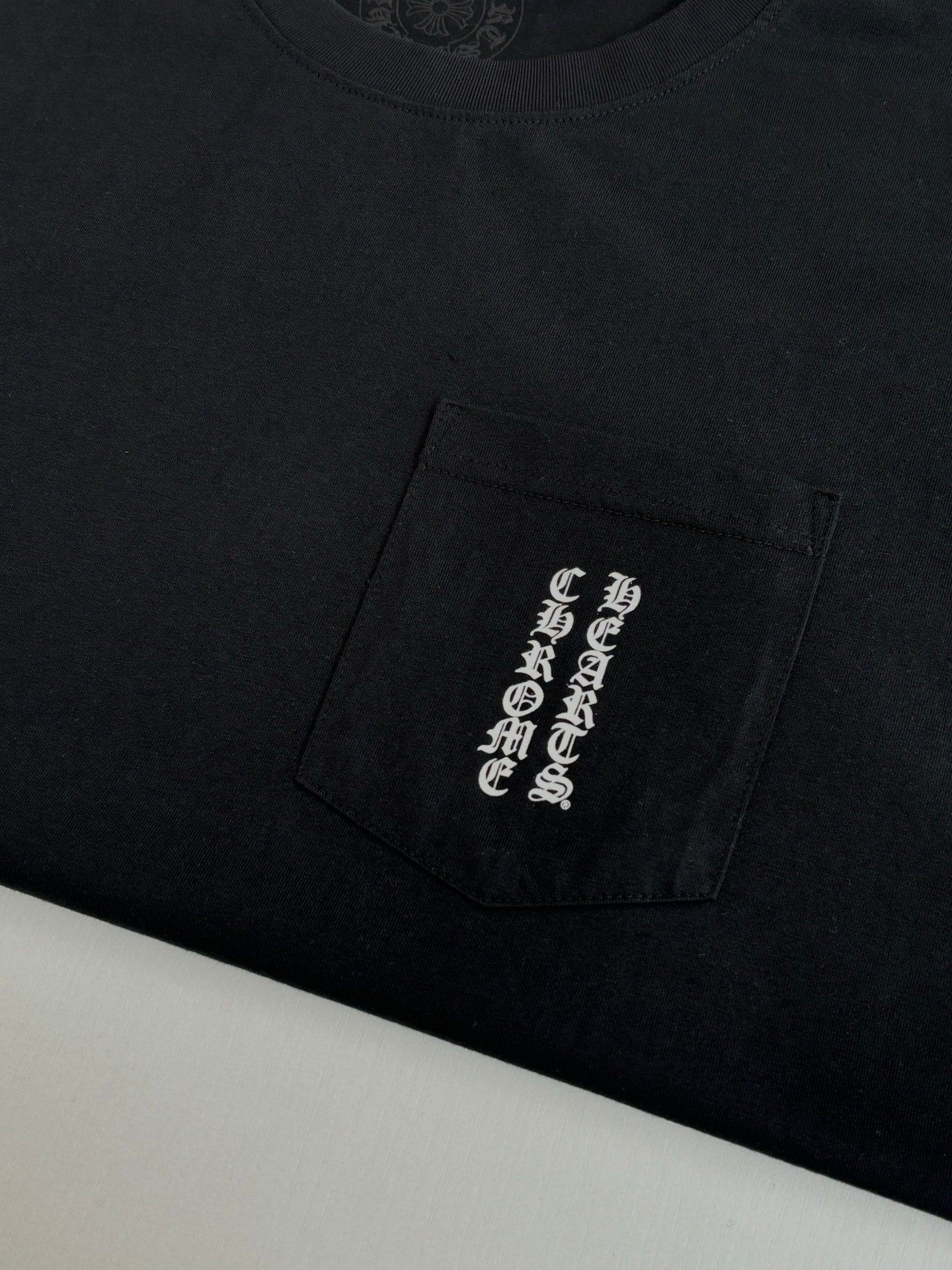 Black T-shirt with rectangular chest pocket graphic patch in light print