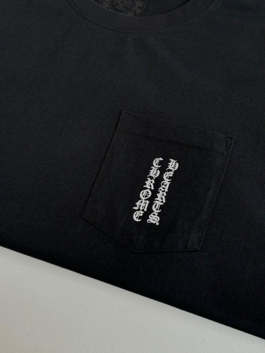 Black T-shirt with pocket-like side graphic patch on lower front