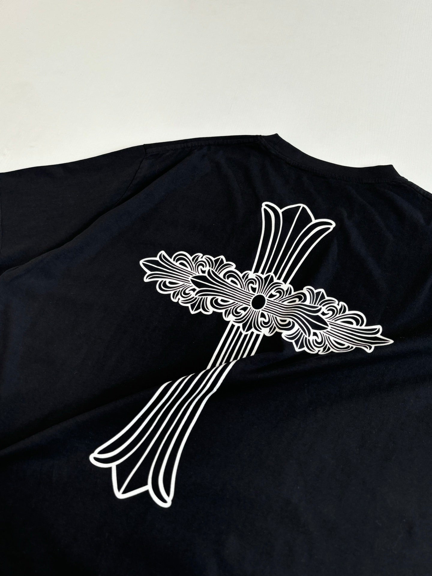 Black short-sleeve T-shirt with large white back cross graphic