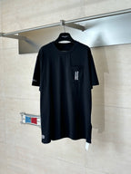 Black crewneck T-shirt on hanger with small chest graphic and short sleeves
