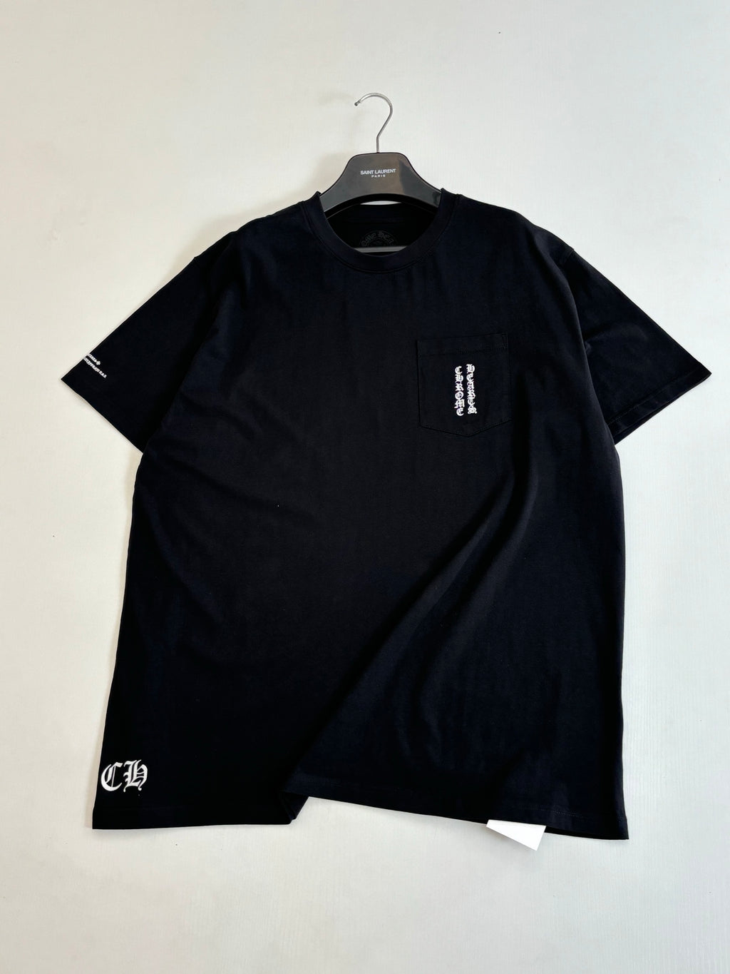 Black crewneck T-shirt with small chest logo patch detail and short sleeves
