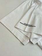 White short-sleeve T-shirt close-up of side seam and small bottom front text print