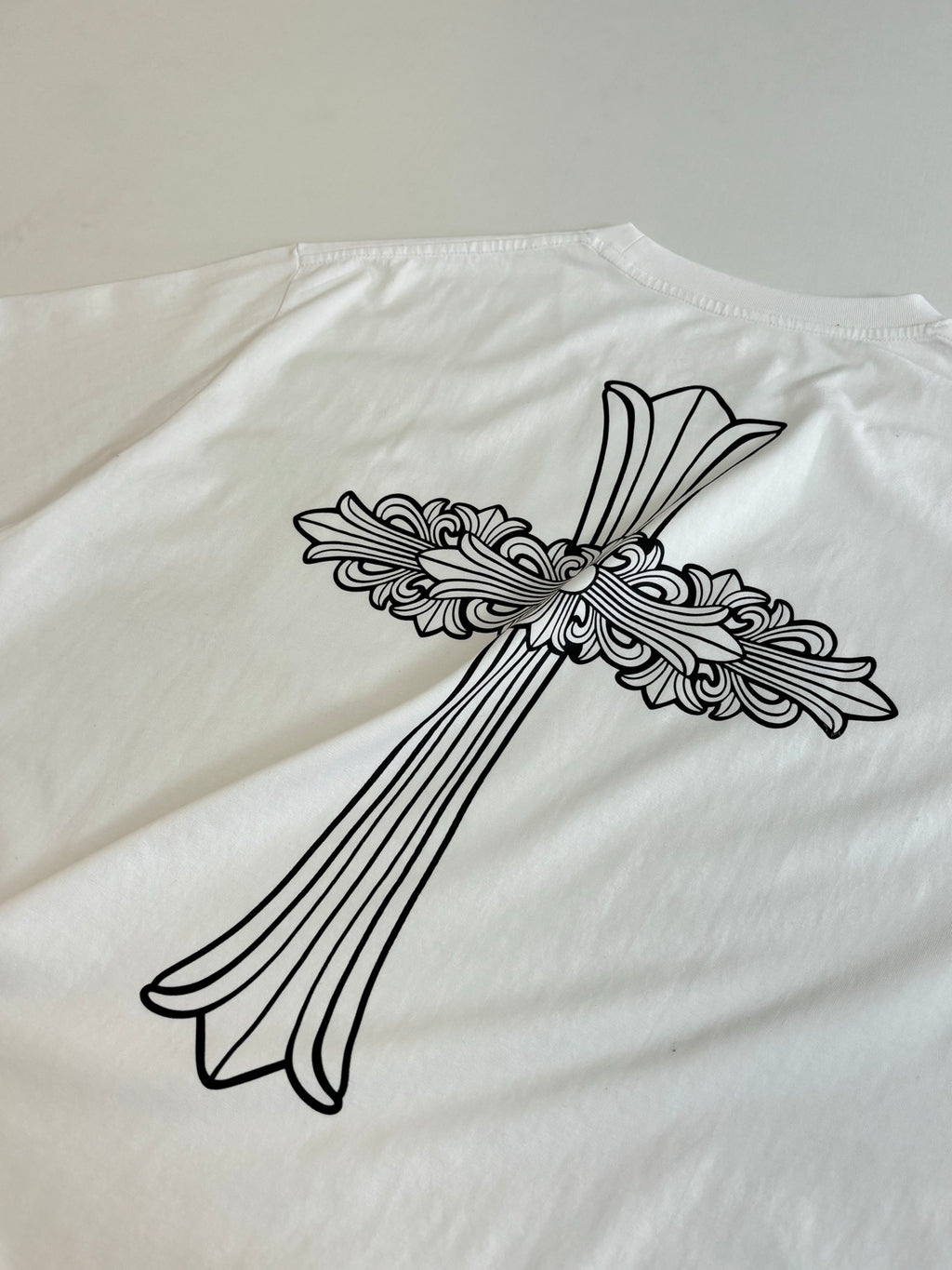 Large back cross-and-flowers graphic on white short-sleeve T-shirt