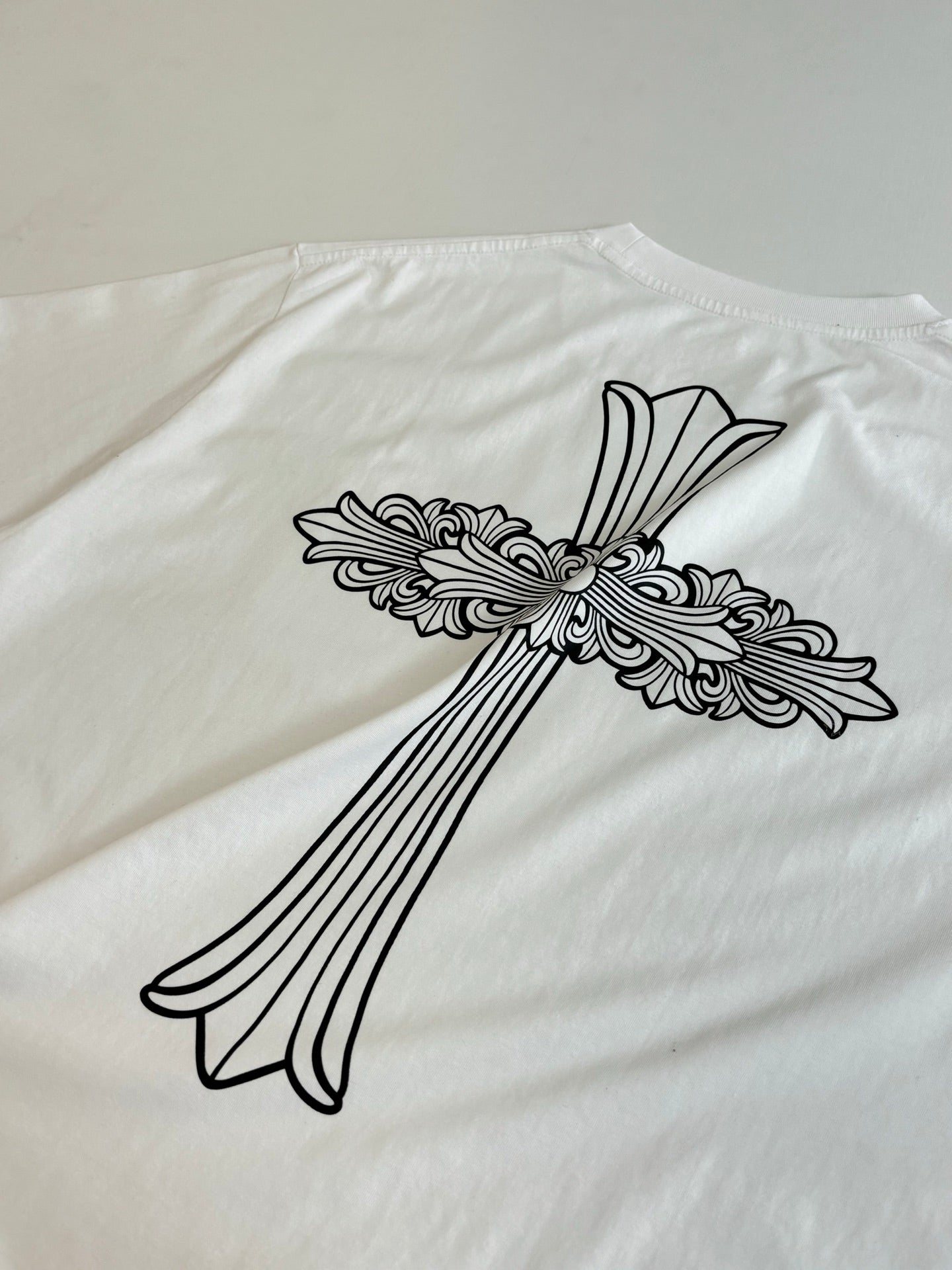 Large back cross-and-flowers graphic on white short-sleeve T-shirt