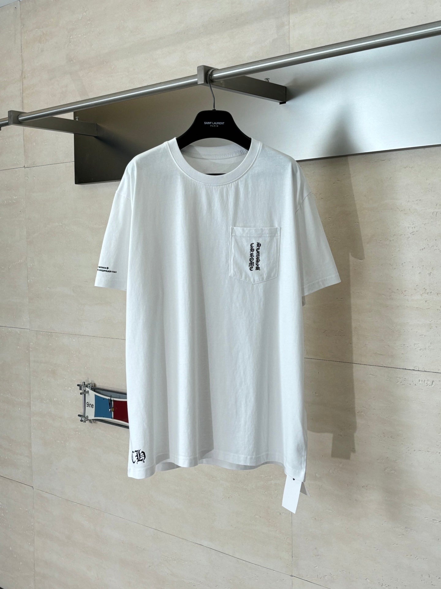 White short-sleeve T-shirt on hanger, crew neck, small chest logo graphic