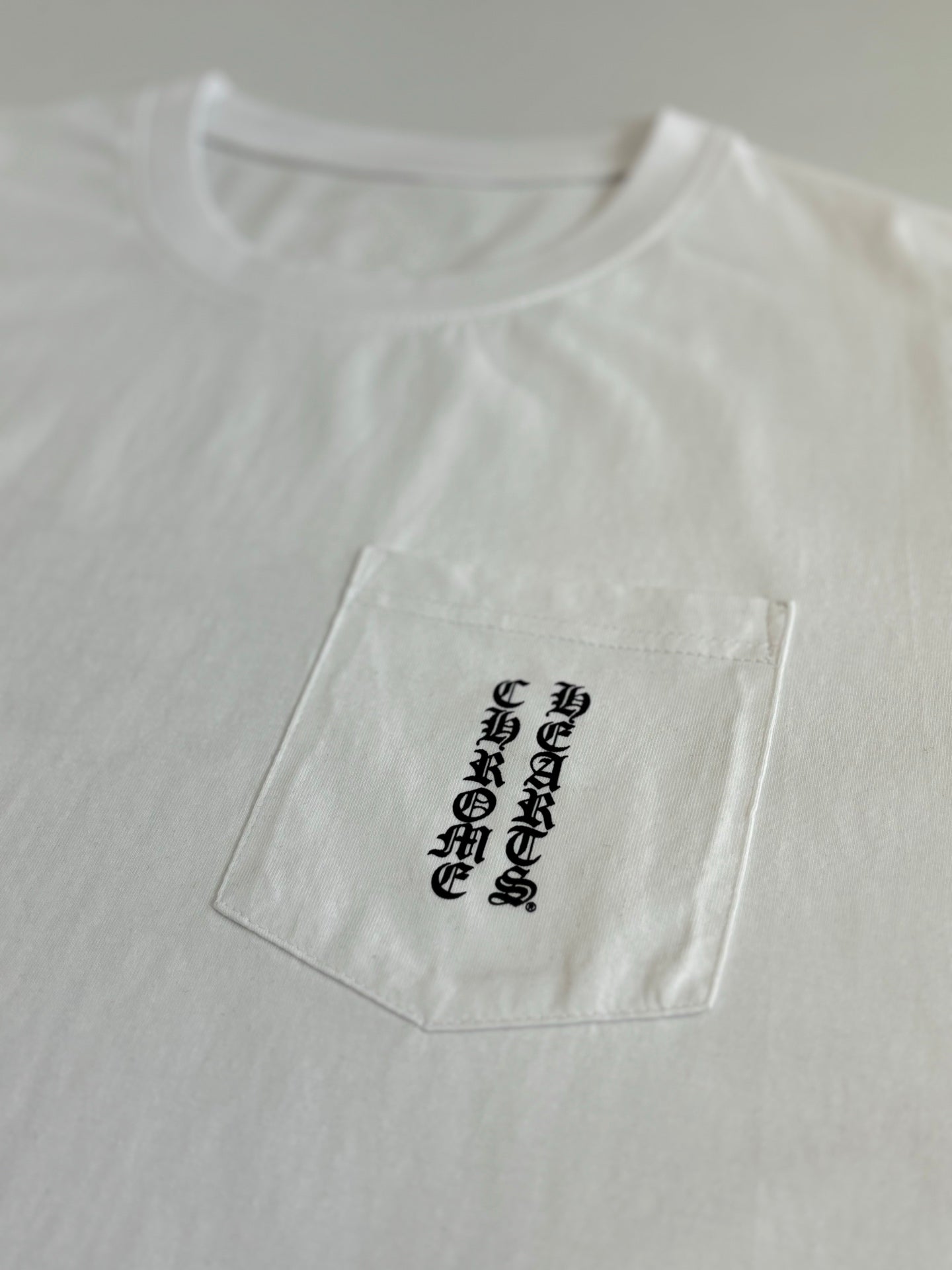 White short-sleeve T-shirt close-up, side chest print with black graphic