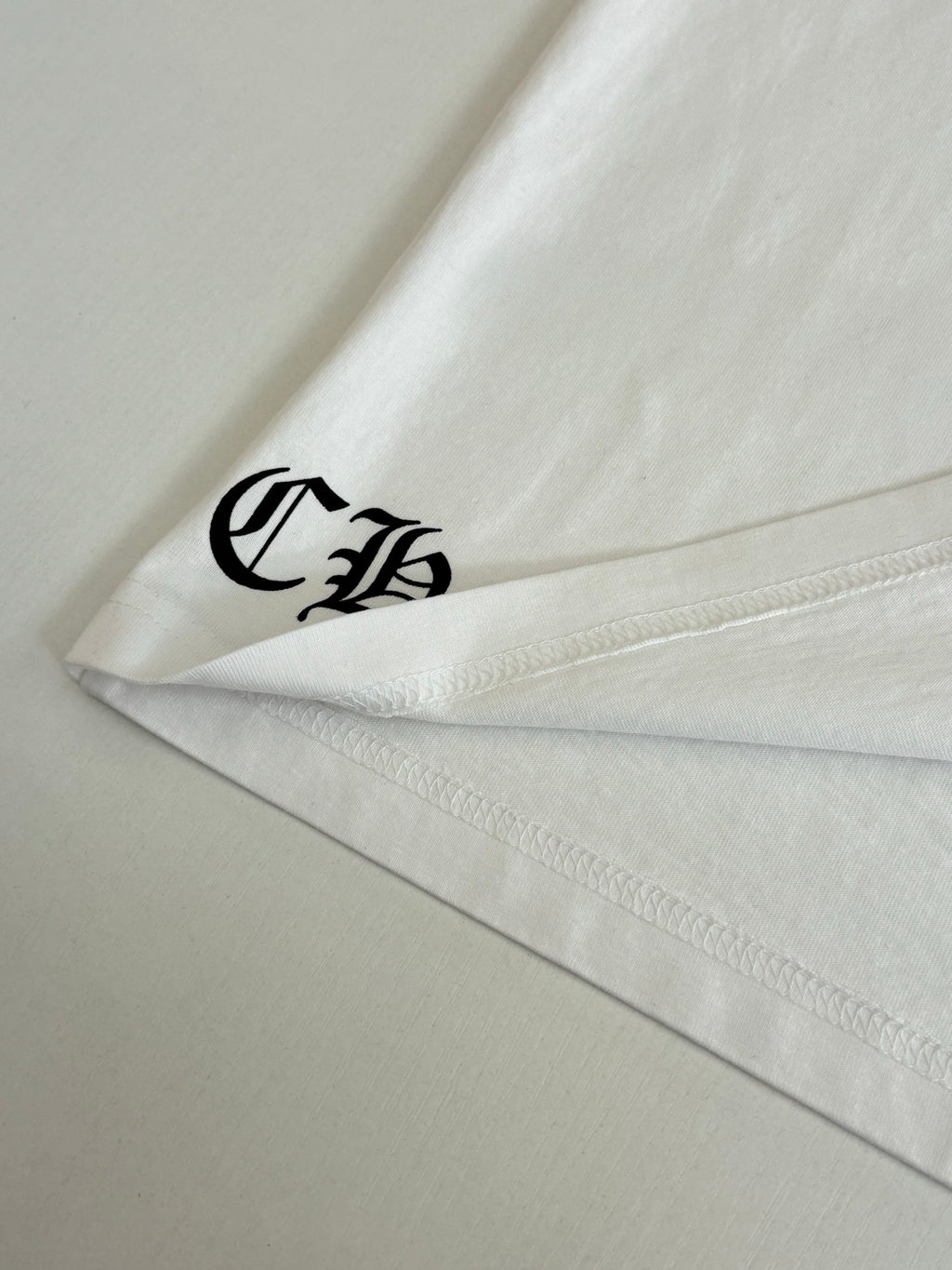 White short-sleeve T-shirt close-up of sleeve logo near hem