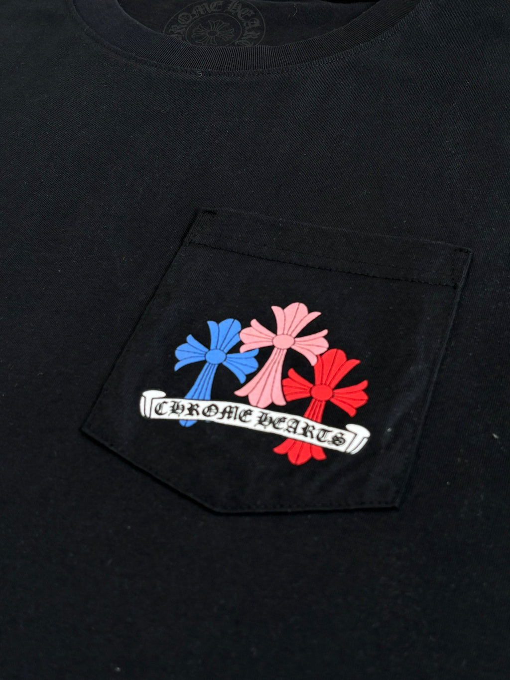 Black short-sleeve T-shirt with colorful floral emblem graphic on the front