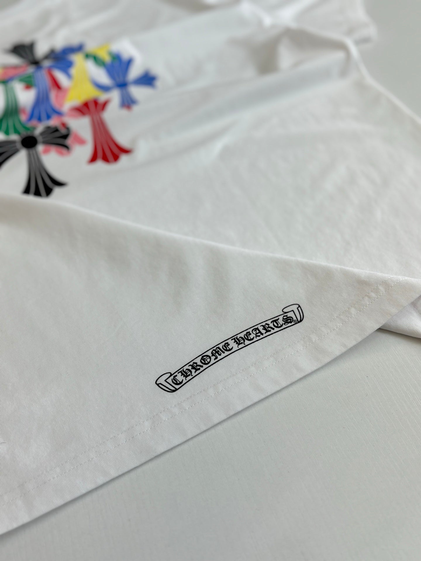 White T-shirt hem with outlined logo text graphic