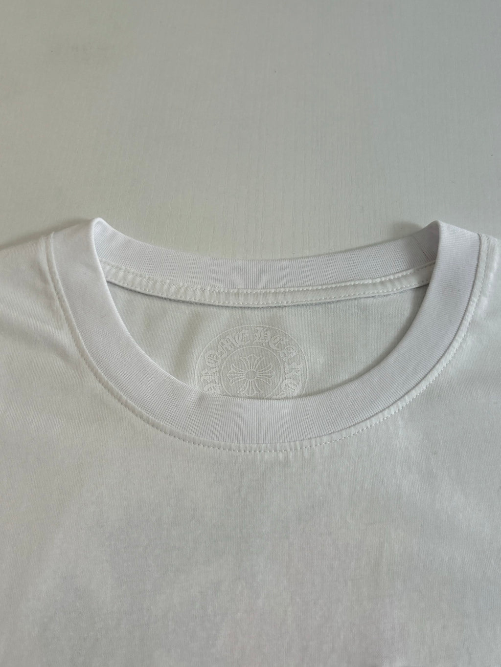 White T-shirt crew neck with subtle embossed collar logo