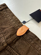 Louis Vuitton brown denim pants with tan leather logo patch and double-stitched seams